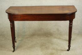 A George III mahogany D shaped hall table, raised tapering on tapering turned supports terminating