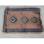 A 20th century Afghan Kazak style blue, pink and green rug with three central lozenges. L.46 W.60cm.