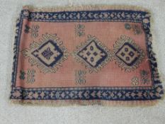A 20th century Afghan Kazak style blue, pink and green rug with three central lozenges. L.46 W.60cm.
