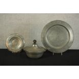 Three pieces of pewter comprising of pewter comprising of two chargers and a twin handled tureen and