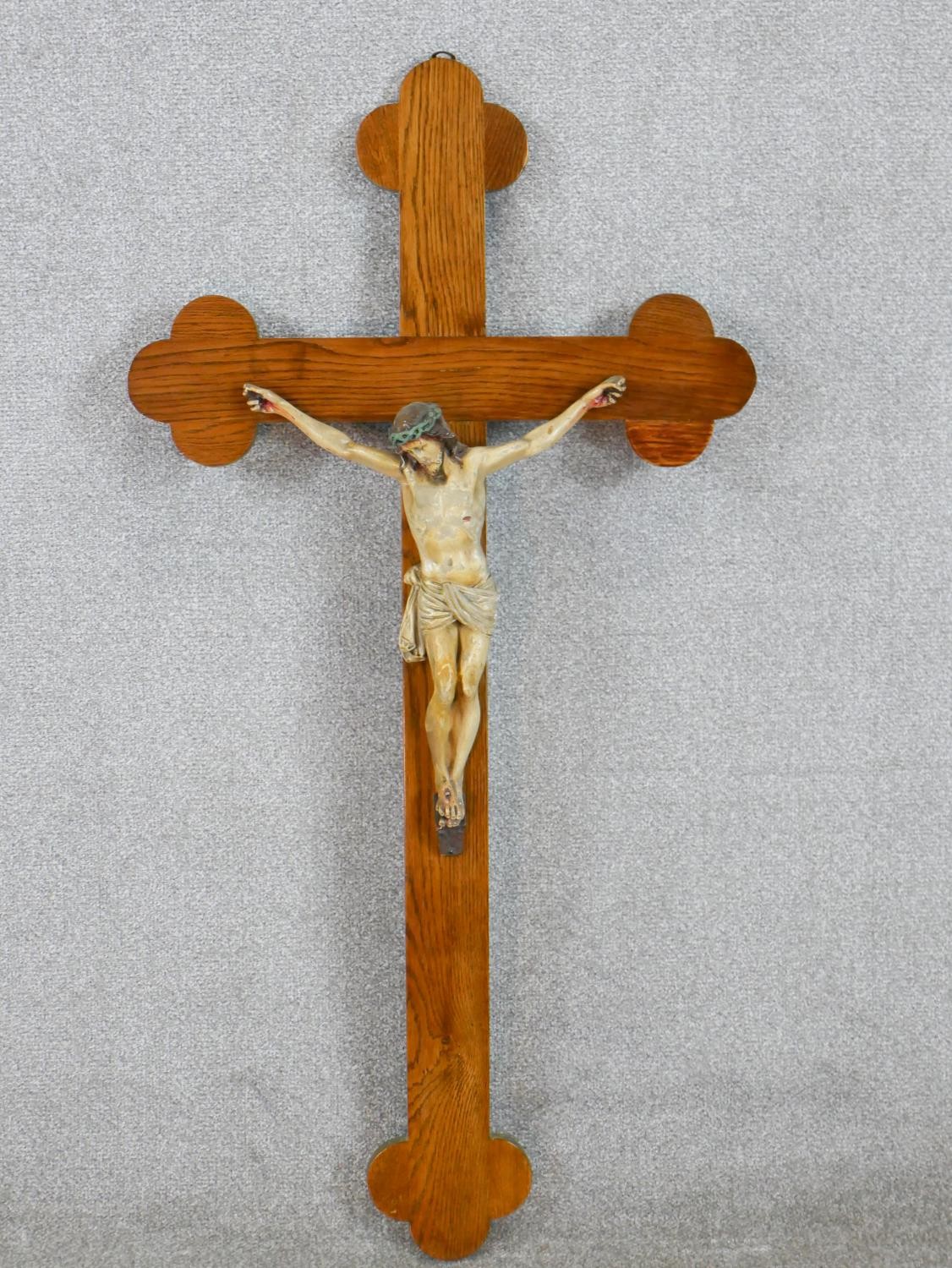 A late 19th/early 20th century oak form crucifix, mounted with a painted carved figure of Jesus