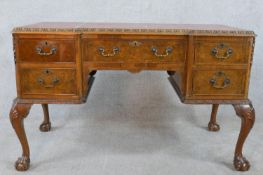 A mid 20th century walnut Georgian style inverted breakfront writing desk, with two banks of two