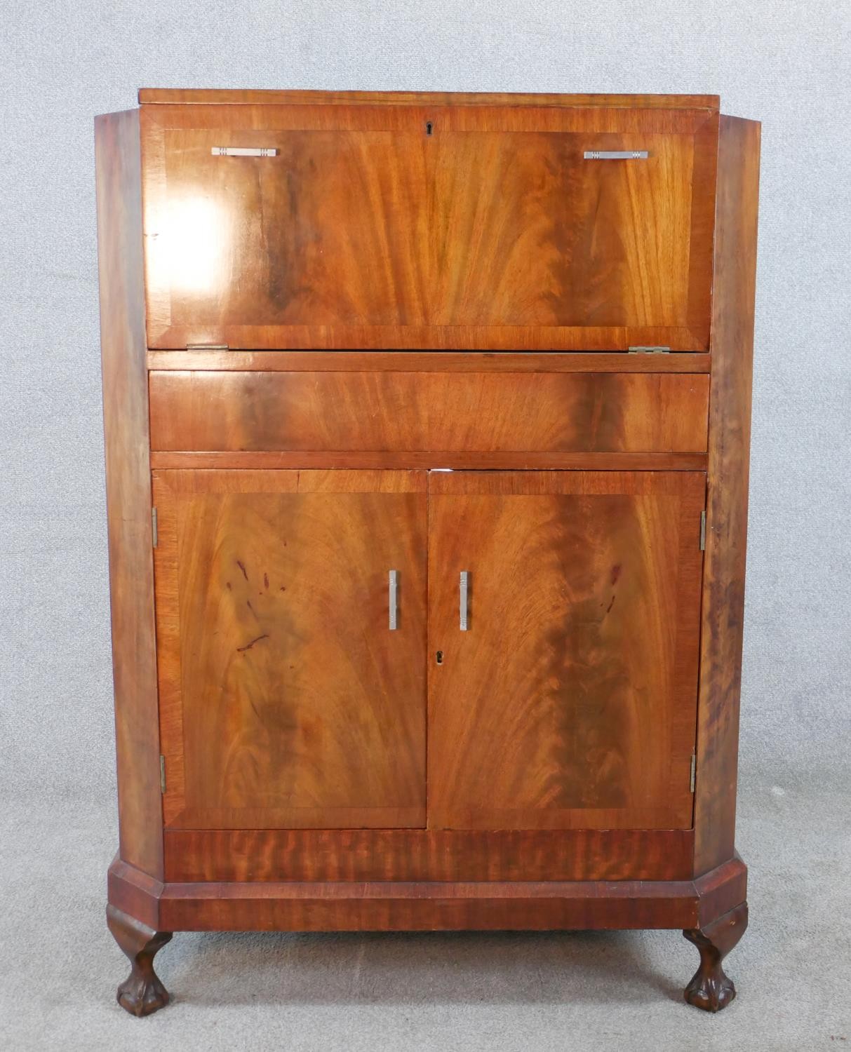 A 1930s walnut veneered drinks cabinet, the hinged lid opening to reveal fitted interior, with