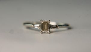 A boxed Art Deco style platinum and diamond flanked solitaire ring. Set to centre with a 0.51