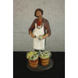 A 20th century Russian painted pottery figure of a a fishmonger, impressed marks. H.25 W.13 D.11cm.