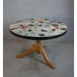 A 20th century circular table, with painted mosaic effect top raised on turned central pine column