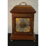 A 20th century mahogany cased eight day mantle clock with brass swing carrying handle, the