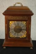 A 20th century mahogany cased eight day mantle clock with brass swing carrying handle, the