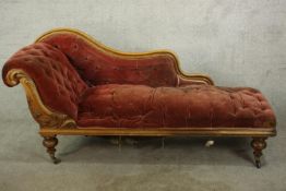 An 19th century mahogany framed chaise longue, with scroll arm and button and quilted style orange