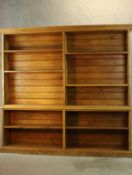 A large early 20th century golden oak double sidedopen library bookcase, raised on plinth base.