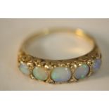 A 9ct carat yellow gold carved half hoop five stone Opal and diamond ring. Set with five round