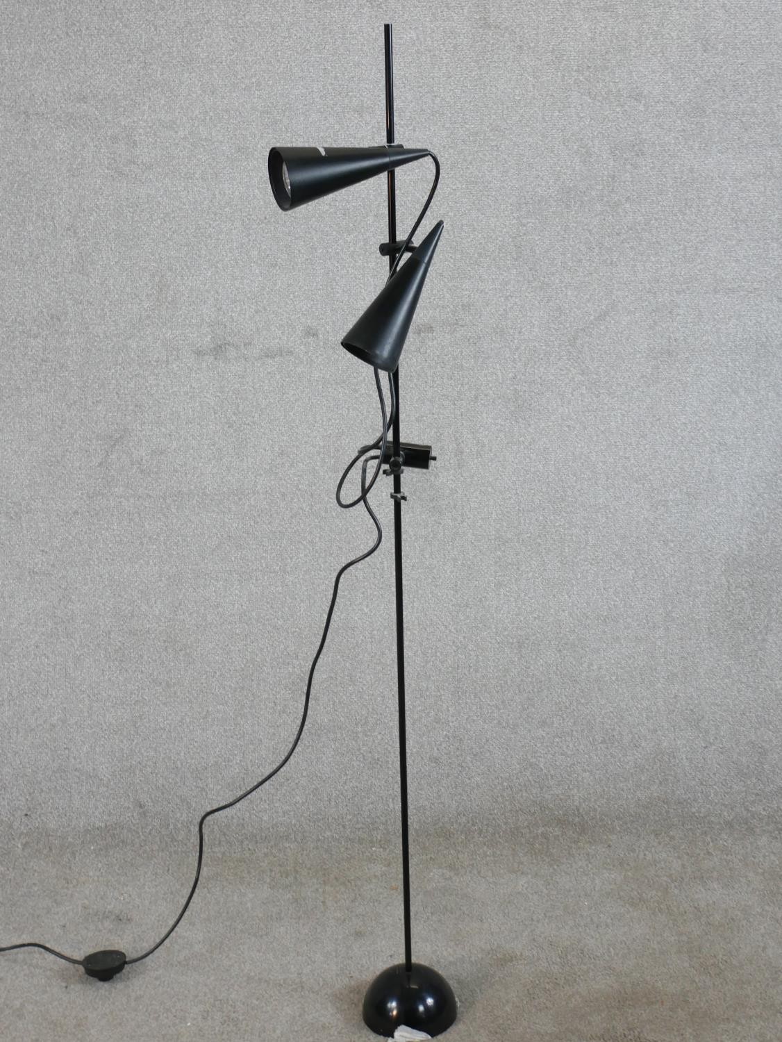 A contemporary floor standing painted metal two branch reading light raised on domed foot. H.138cm