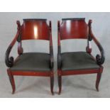 A pair of Regency style mahogany open arm chairs, with drop in seats, the scroll arms with carved