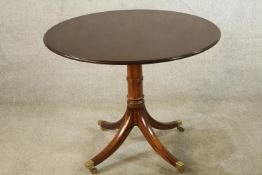 A late 19th/early 20th century mahogany circular tilt top table, raised on turned central column