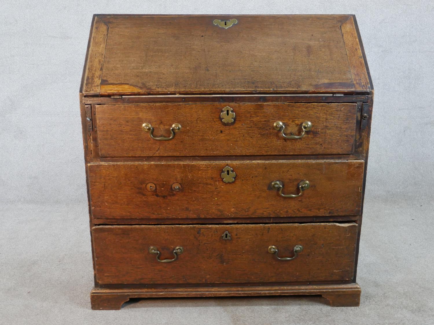 A 19th century oak fall front bureau, the fall front opening to reveal fitted interior, above