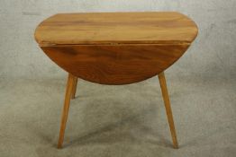 A mid 20th century blonde elm Ercol drop leaf table, raised on splayed supports. H.70 W.104 D.103cm.