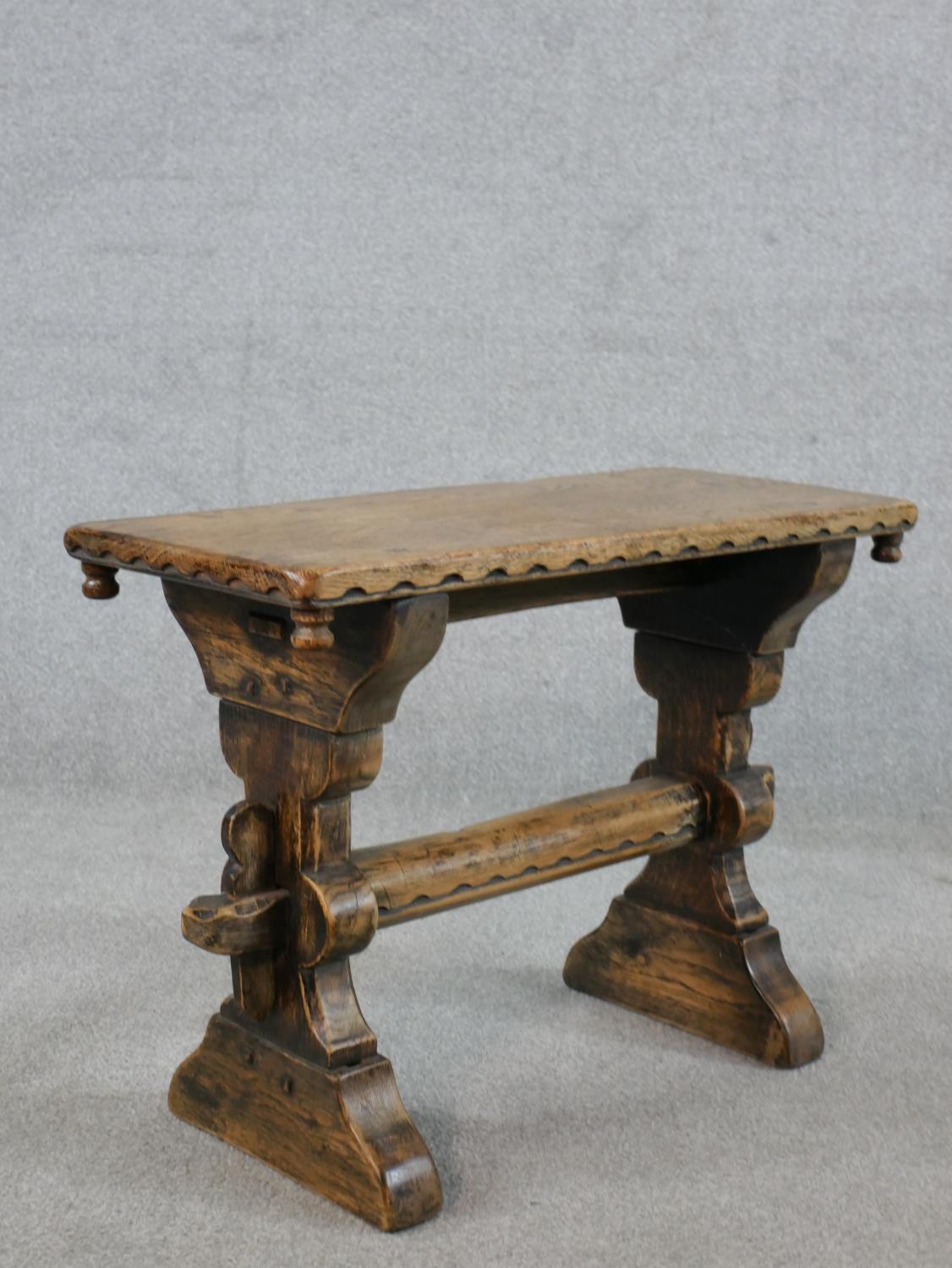 A late 19th/early 20th century stained oak stool, raised on carved trestle supports with block feet. - Image 5 of 5