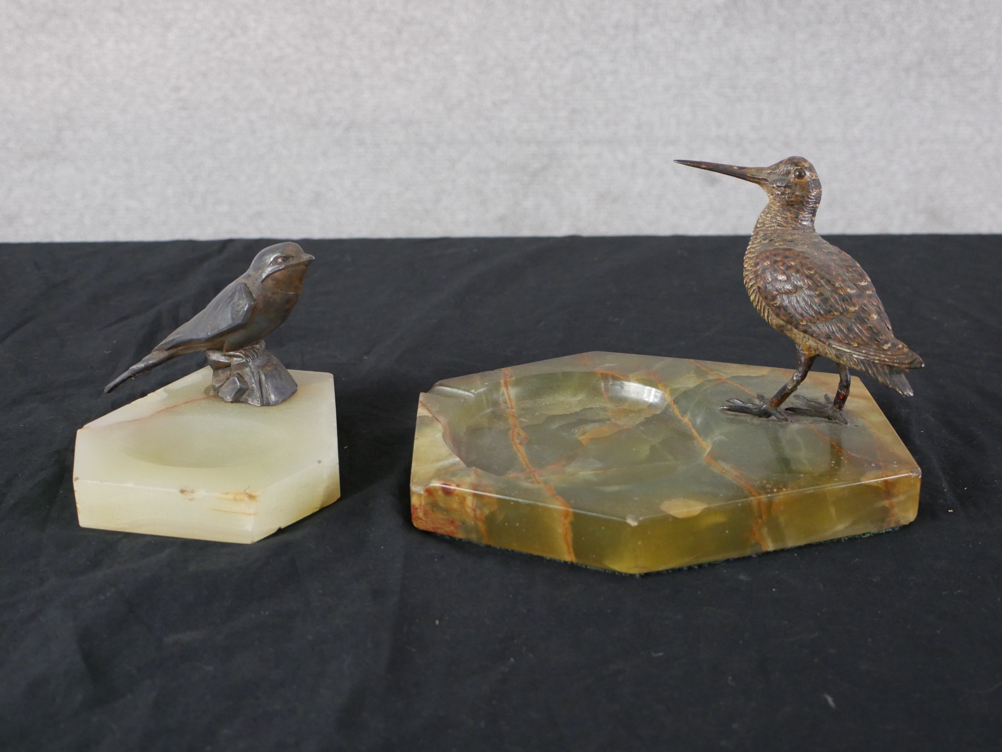 An Art Deco cold painted bronze model of a Snipe mounted on a hexagonal onyx ashtray, together