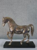 A 20th century silver plated prancing horse, raised on black rectangular plinth base. H.25 W.25.5