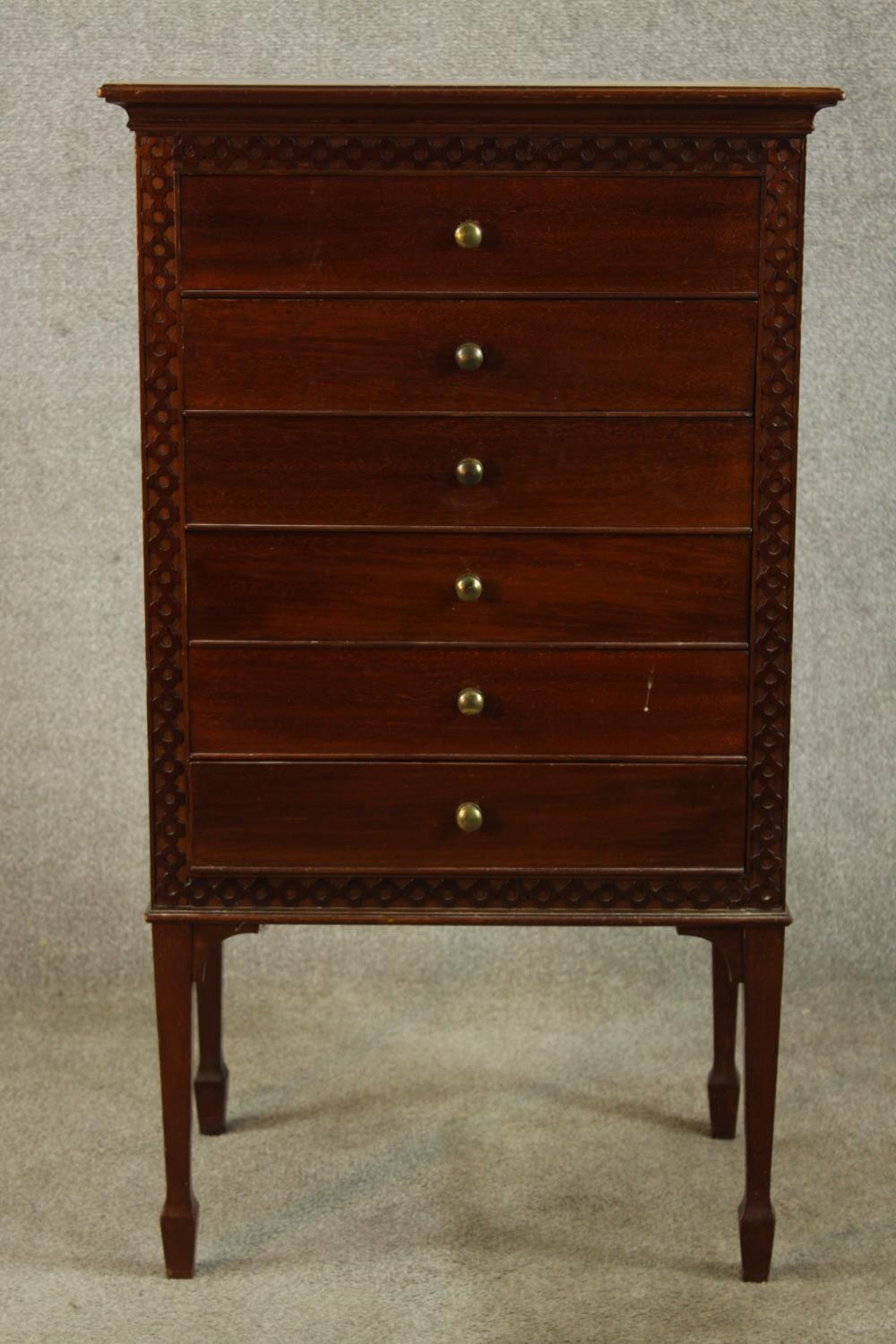 An Edwardian mahogany six drawer music cabinet with brass knop handles, raised on square tapering