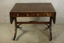 A 19th century mahogany sofa table, raised on four splayed supports terminating on brass capped feet