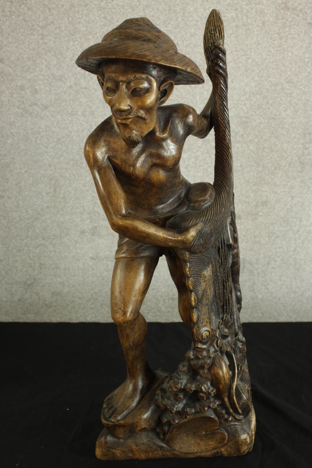 An early 20th century carved Chinese hardwood fisherman, raised on naturalistic base. H.63 W.25 D. - Image 6 of 6