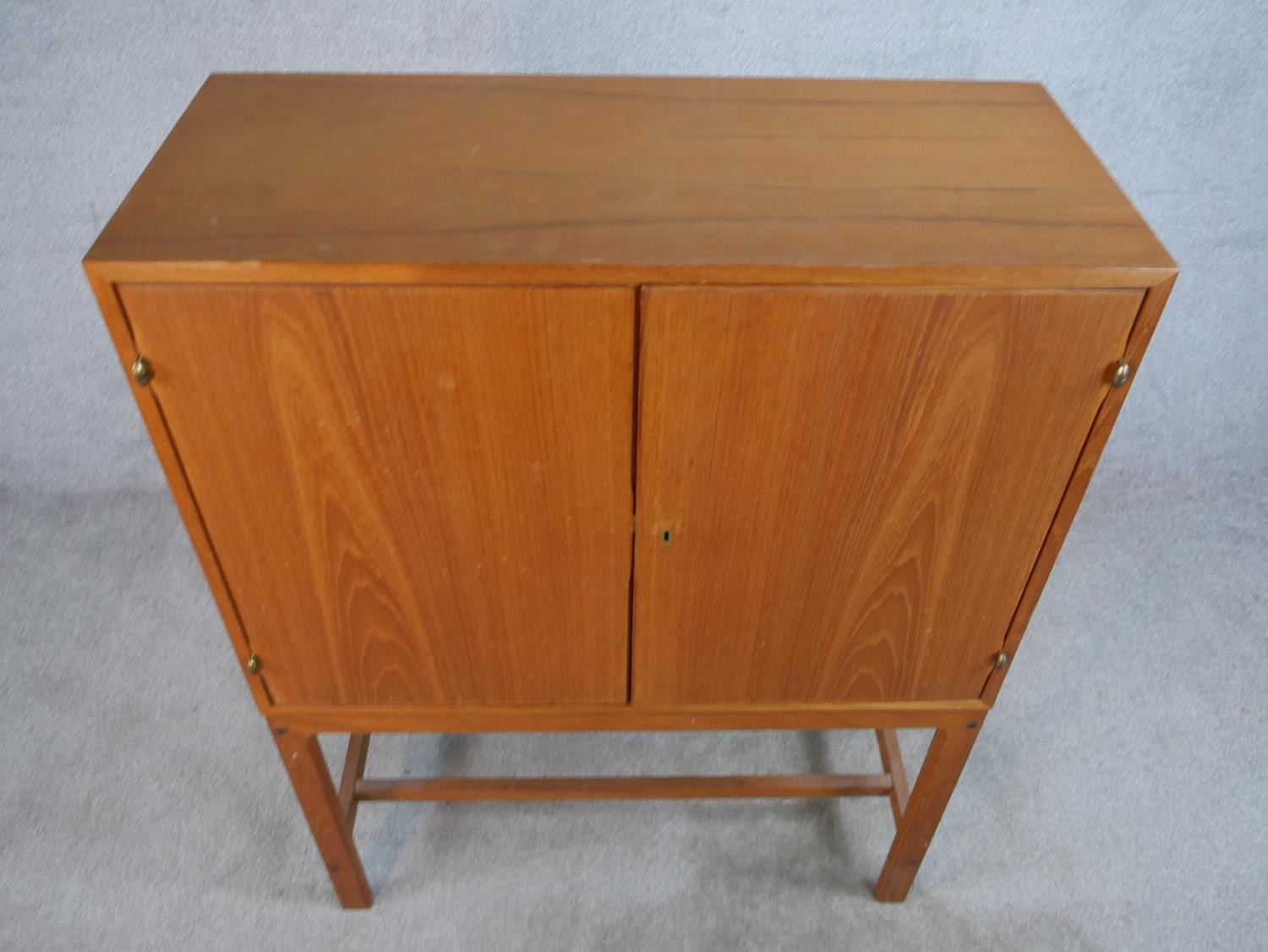 A mid 20th century Danish teak two door cupboard, opening to reveal three shelves, raised on - Image 2 of 7
