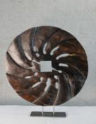 “The Grind” (by Angus Clyne - Scottish). A contemporary pierced walnut circular sculpture, raised on