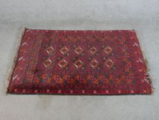 A 20th century red ground Belouch style Persian rug with all over geometric pattern. W.137 D.51cm