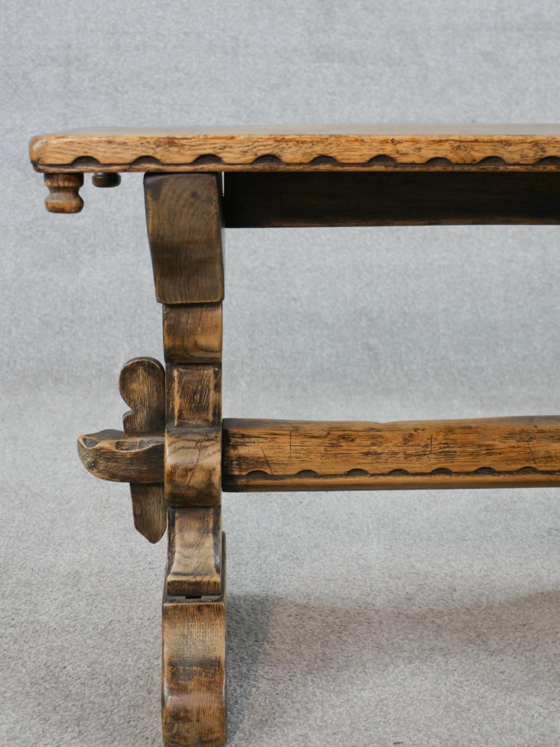 A late 19th/early 20th century stained oak stool, raised on carved trestle supports with block feet. - Image 4 of 5