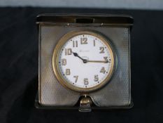 An Art Deco hallmarked silver cased 8 day strut clock, retailed by Harrods, the white dial with gilt