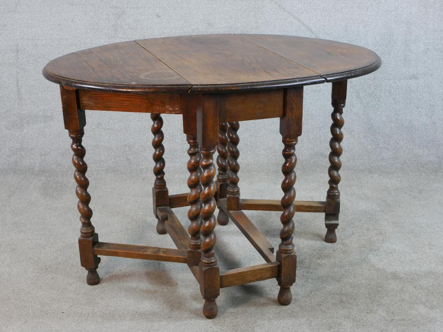 An early 20th century oak drop leaf gate leg table, raised on barley twist supports terminating in - Image 5 of 5