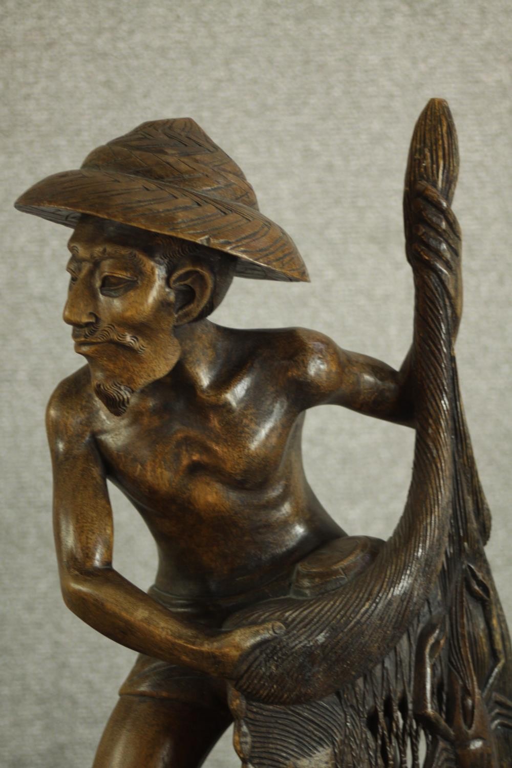 An early 20th century carved Chinese hardwood fisherman, raised on naturalistic base. H.63 W.25 D. - Image 3 of 6