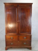 A 19th century mahogany twin door linen press, opening to reveal slides with a two short and
