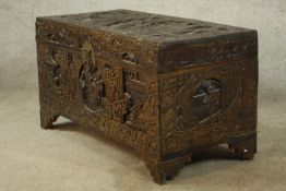 An early 20th century carved Chinese camphorwood trunk, with twin swing handles, raised on shaped