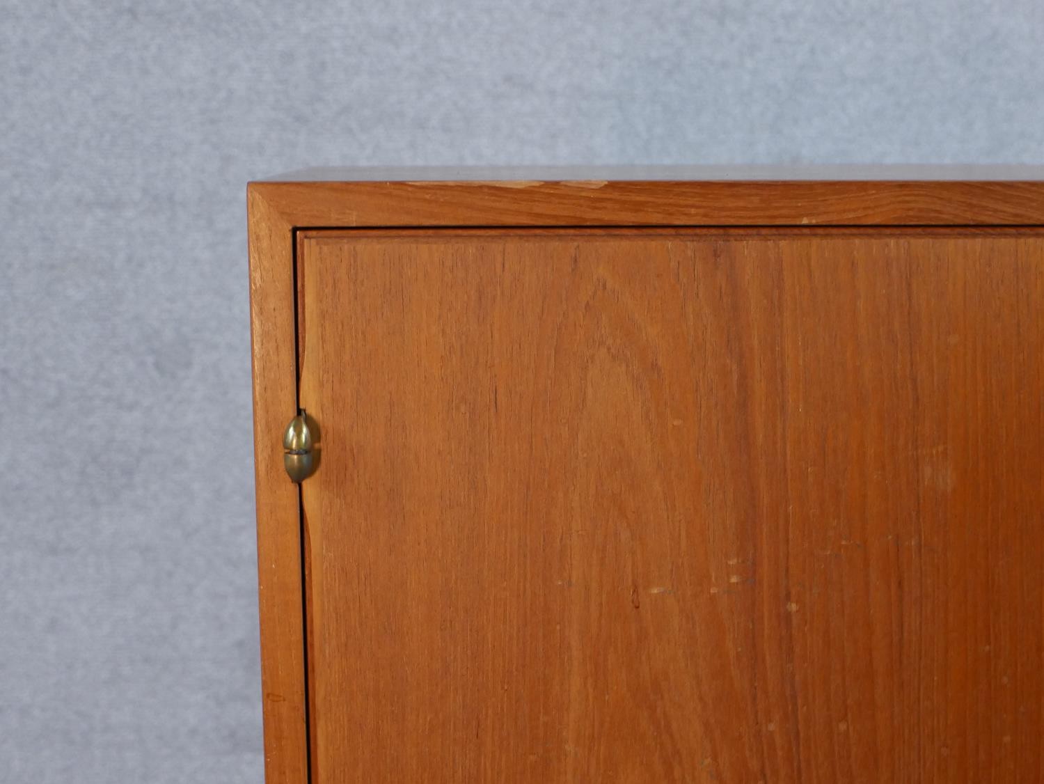 A mid 20th century Danish teak two door cupboard, opening to reveal three shelves, raised on - Image 6 of 7