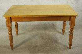 A 20th century pine rectangular farmhouse kitchen table, raised on turned supports. H.77 W.136 D.