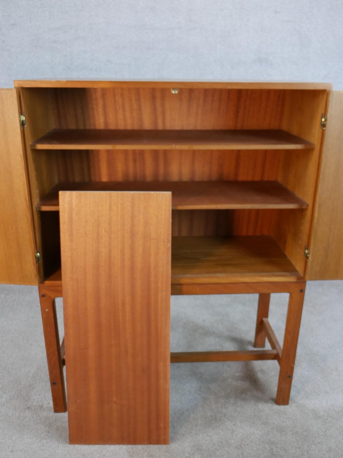 A mid 20th century Danish teak two door cupboard, opening to reveal three shelves, raised on - Image 5 of 7