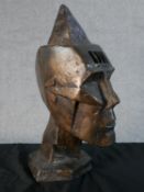 A contemporary copper effect modernist spelter head of angular shape raised on plinth base. H.39 W.