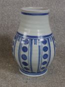 A mid 20th century blue and white Poole pottery vase, decorated with circles and abstract pattern,