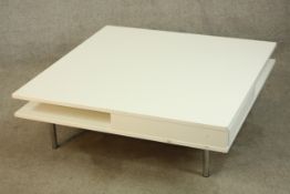A contemporary white polymer veneered two drawer coffee table raised on brushed steel supports. H.30