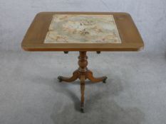 A 19th century walnut tilt top table, inset with tapestry panel, raised on turned central column and