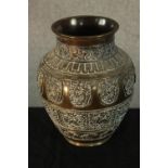 An early 20th century Indian cast brass baluster vase, with incised panels of mythical creature