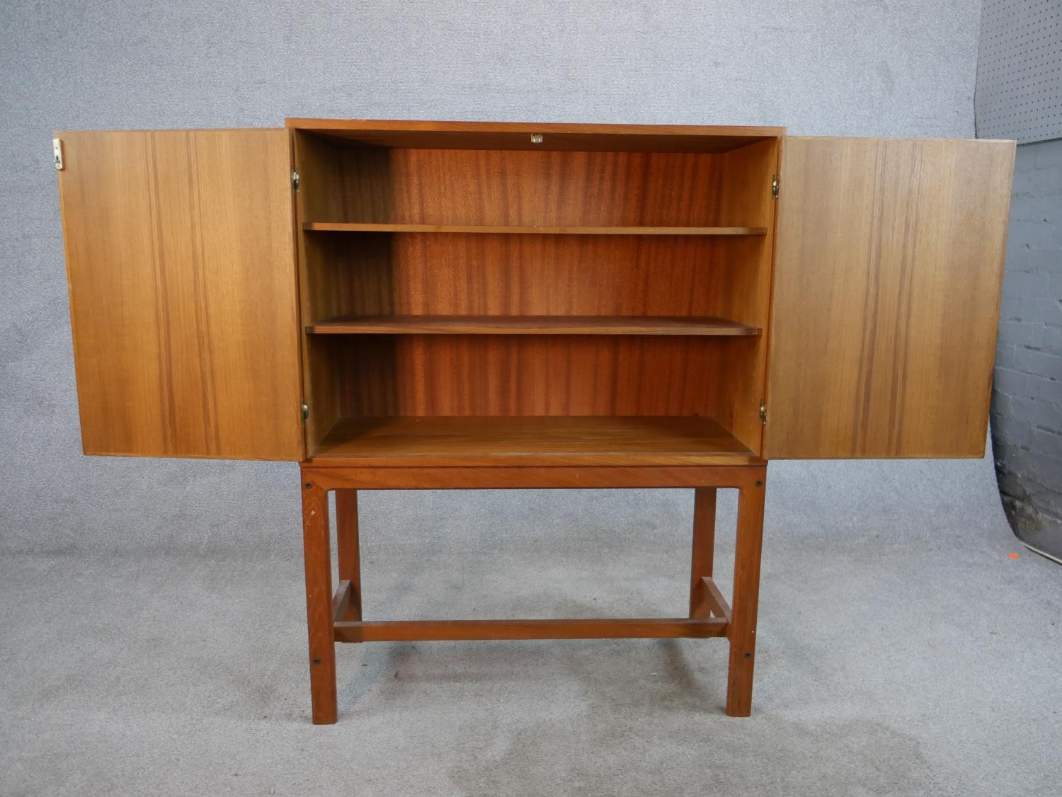 A mid 20th century Danish teak two door cupboard, opening to reveal three shelves, raised on - Image 3 of 7