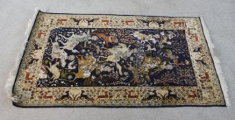 A 20th century North Indian Kashmir silk rug depicting a men on horseback slaying animals within a