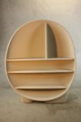 A contemporary painted and weighted modernist fibre glass oval open shelf unit, raised on rounded