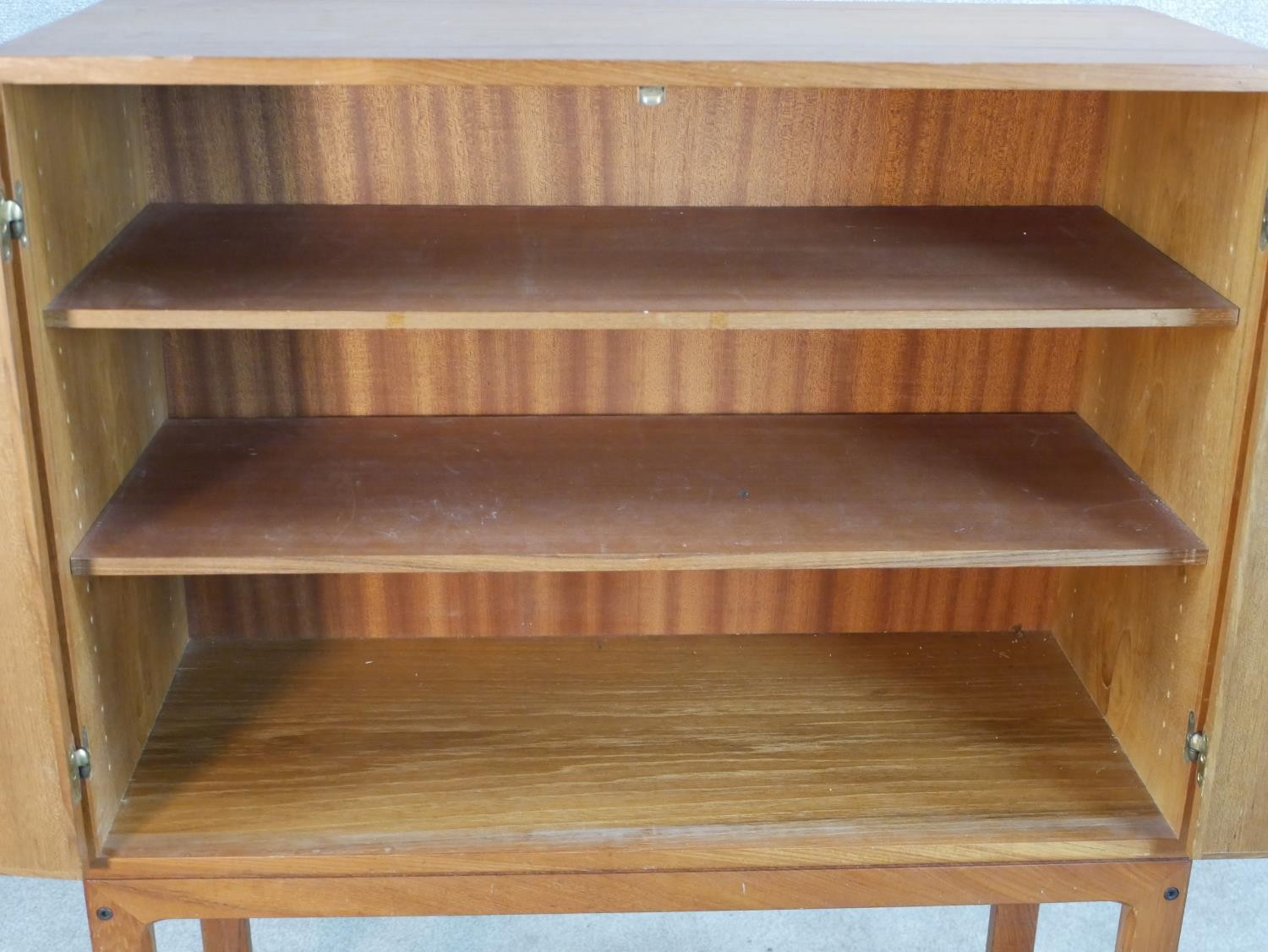 A mid 20th century Danish teak two door cupboard, opening to reveal three shelves, raised on - Image 4 of 7