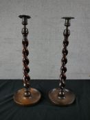 A pair of 19th century barley twist candlesticks, with gilt metal sconces raised on circular