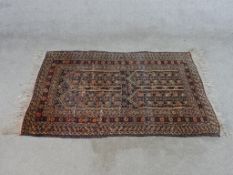 A 20th century Persian rug, embroidered with four quarterly sections within geometric border. W.