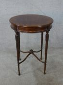 An early 20th century Neo Classical style mahogany circular table, raised on carved and fluted